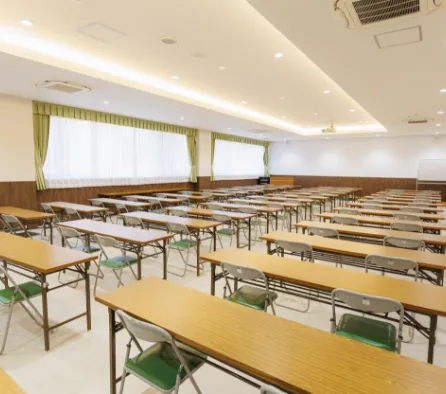 授業で使用される机と椅子が整然と並んだ、明るく整備された校内の教室