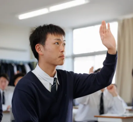 授業中に学生が手を挙げている様子
