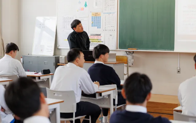 教室でコーチが黒板を使って教えている様子