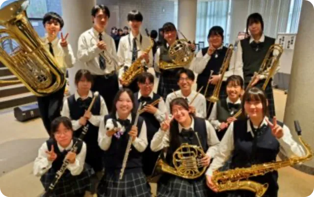 管楽器を手にした吹奏楽部の部員が屋内で集合している様子