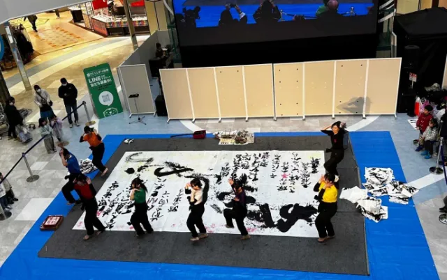ショッピングモールで、大きな紙に書道パフォーマンスをしている様子