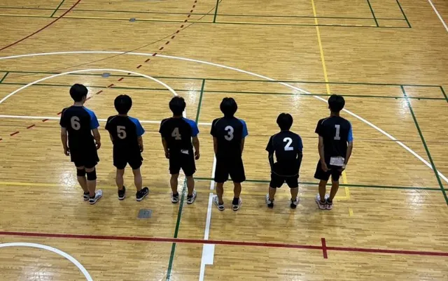 バレーボール部の部員がコートに並んでいる様子