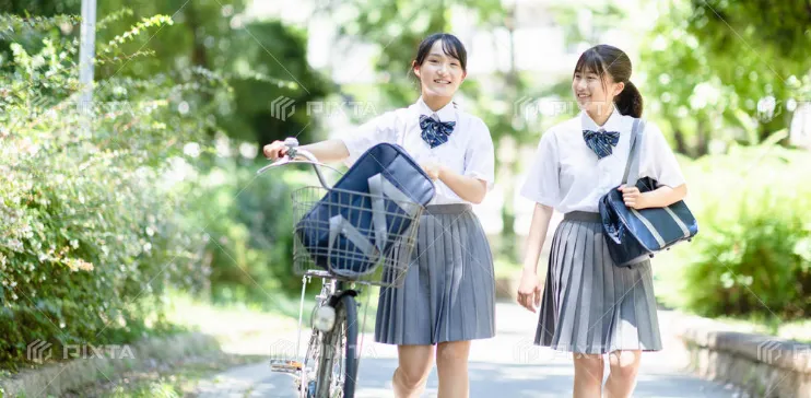 自転車を押しながら学校へ歩く2人